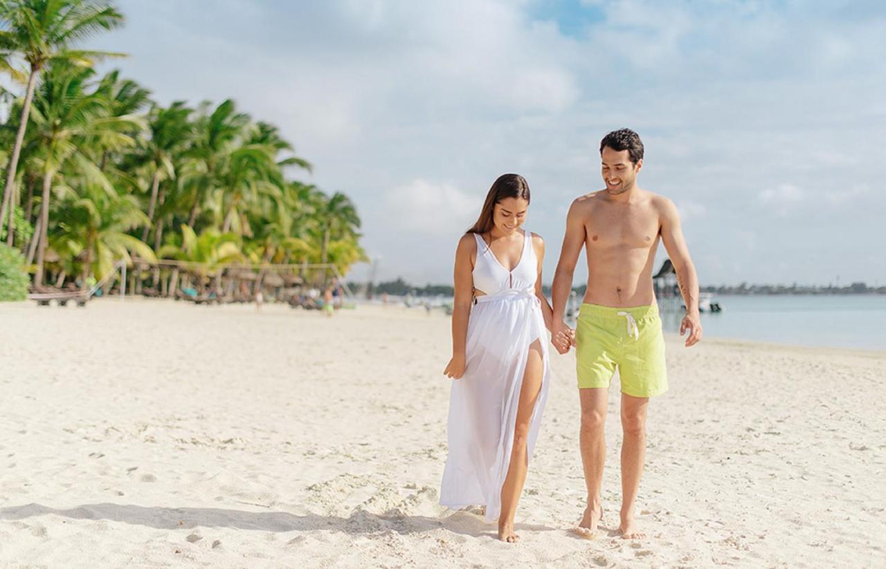 Trou Aux Biches Beachcomber Golf Resort & Spa Esterno foto A couple walking on a beach